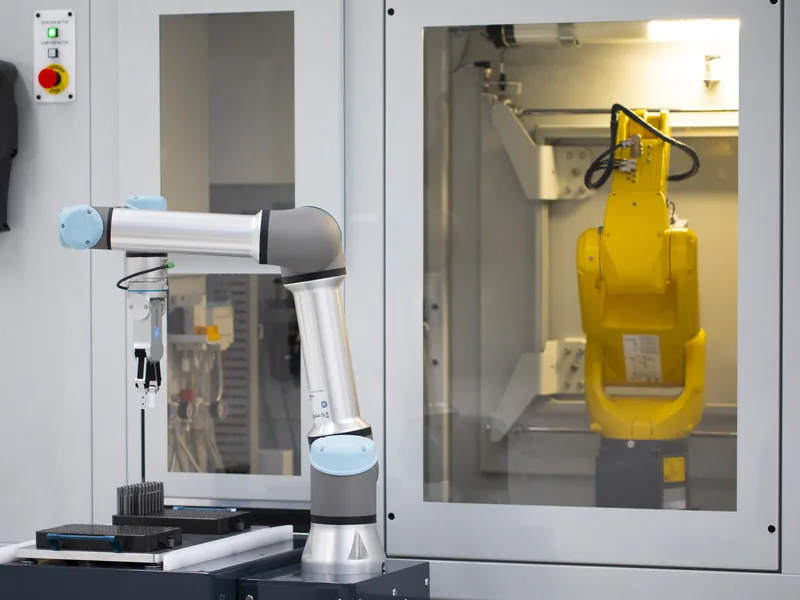 Collaborative robot alongside a guarded industrial robot cell