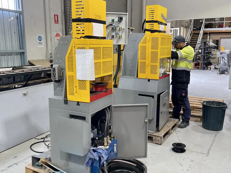 Technician working on a guarded machine control panel in a workshop