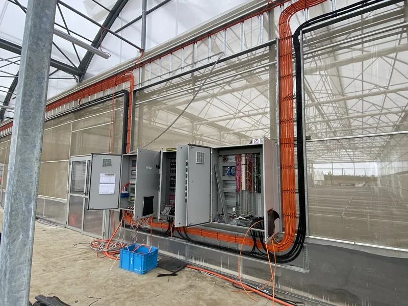 Row of control panels and switchboards along a production facility