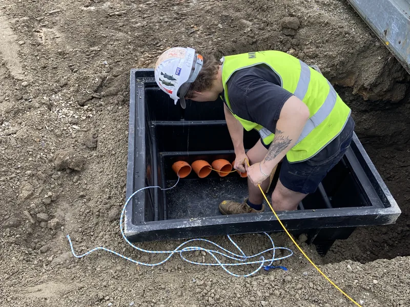 Electrician installing conduits into an underground pit